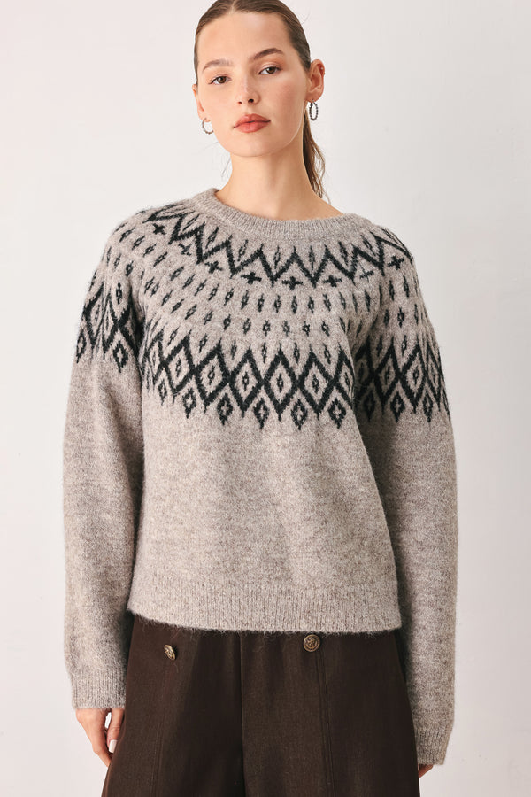 A model wearing a taupe knit sweater with a black geometric pattern across the chest | FREEMARKET