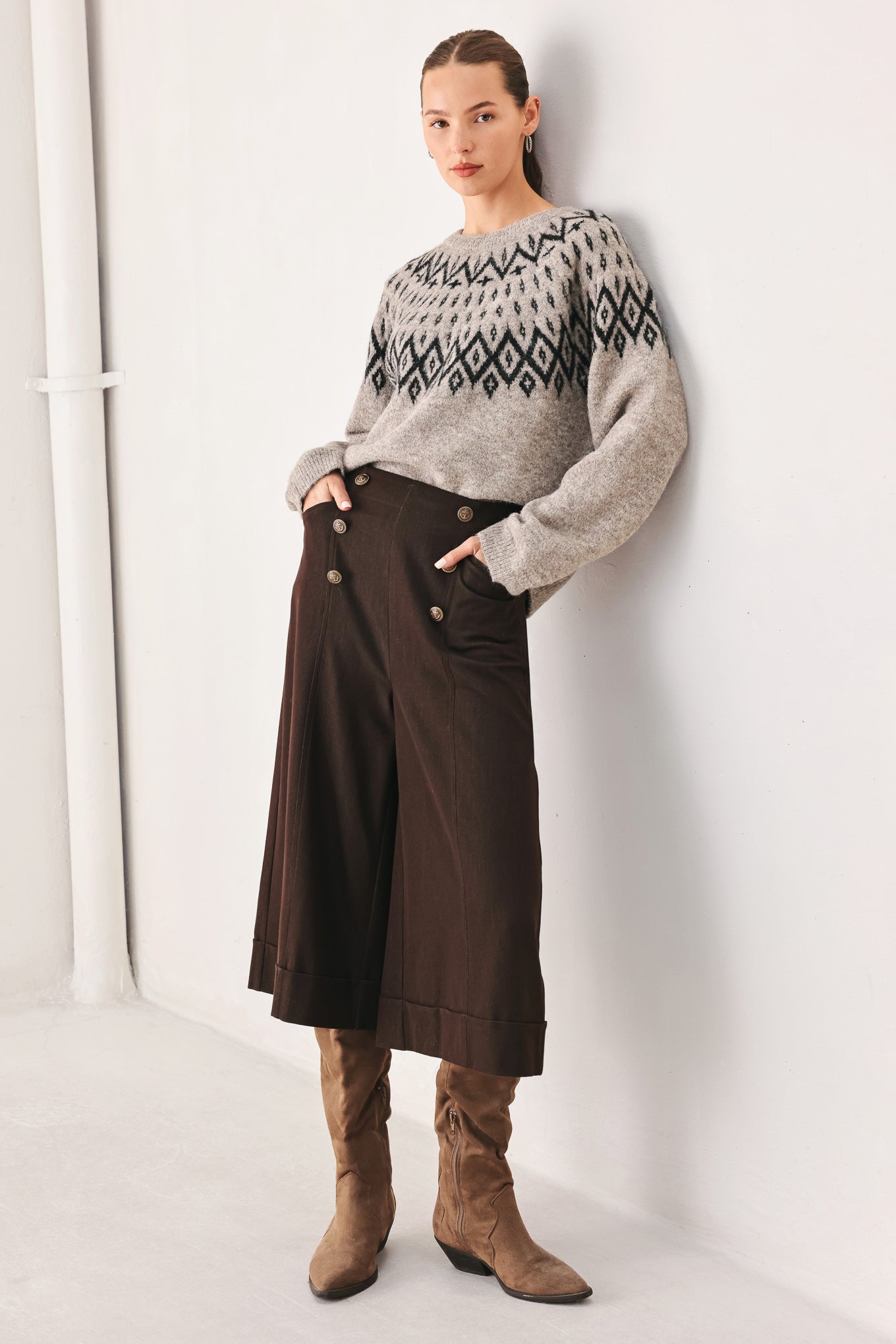 A model wearing a taupe knit sweater with a black geometric pattern across the chest | FREEMARKET