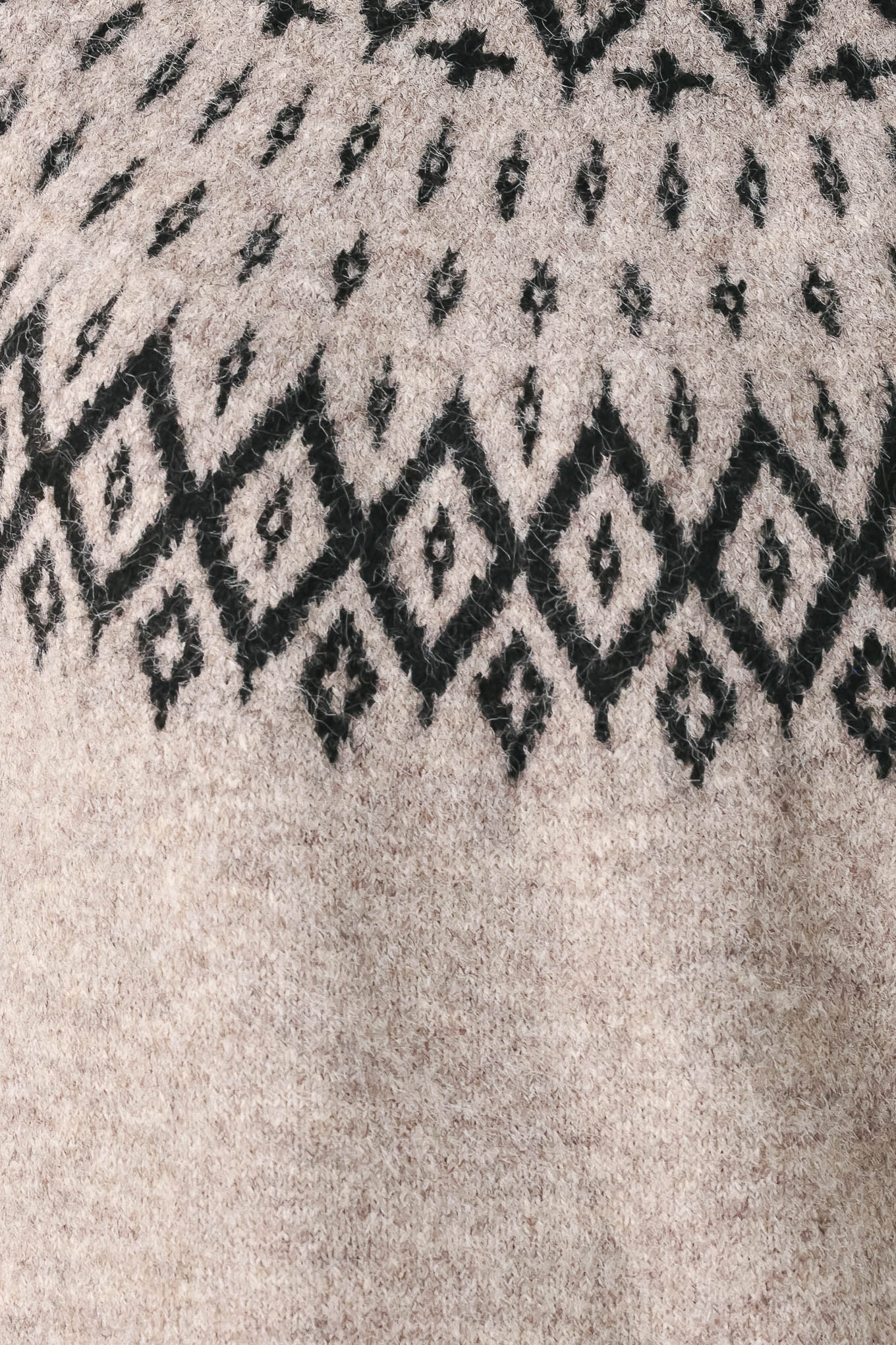 A model wearing a taupe knit sweater with a black geometric pattern across the chest | FREEMARKET