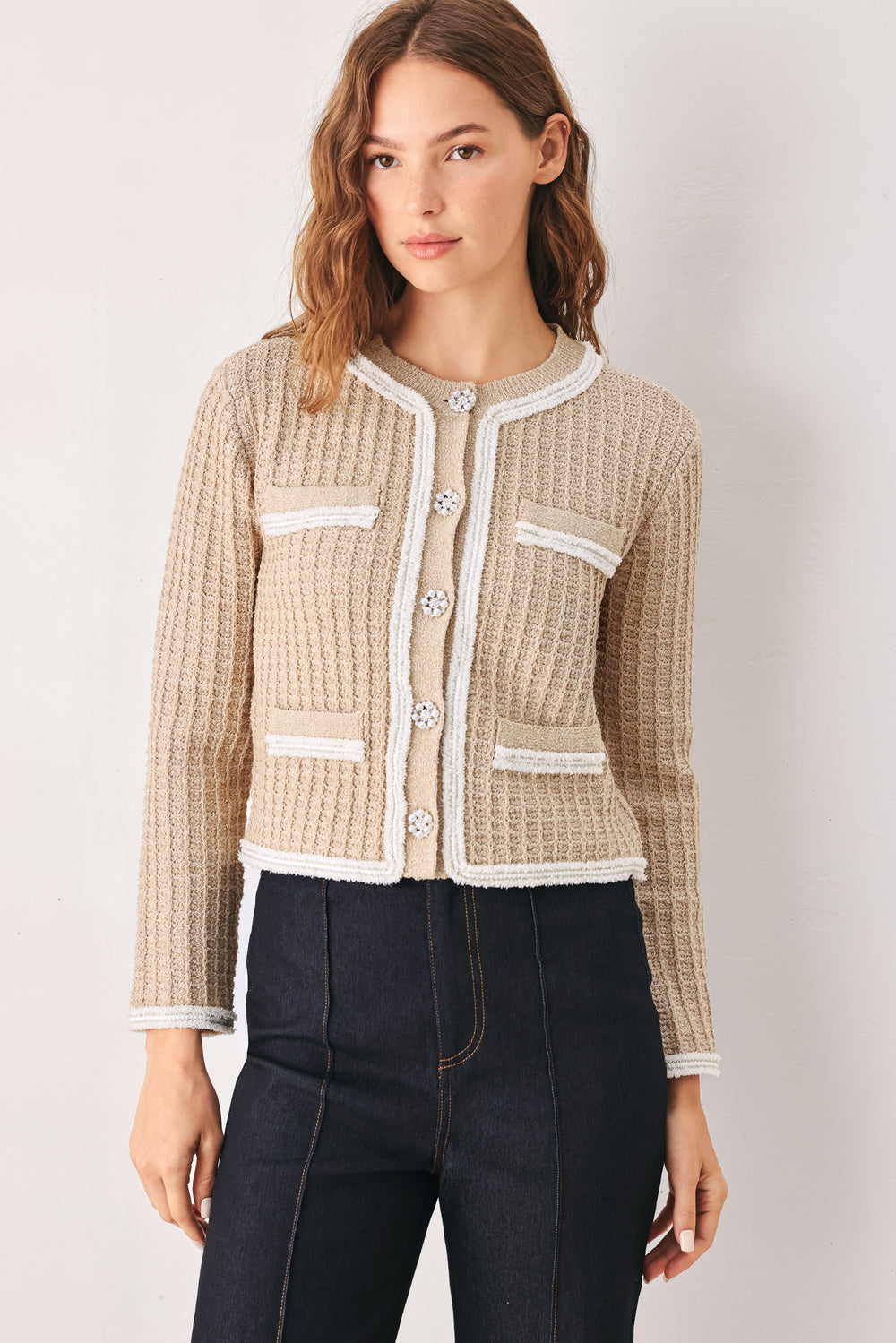 A woman wearing a beige textured knit cardigan with white trim and decorative buttons | FREEMARKET