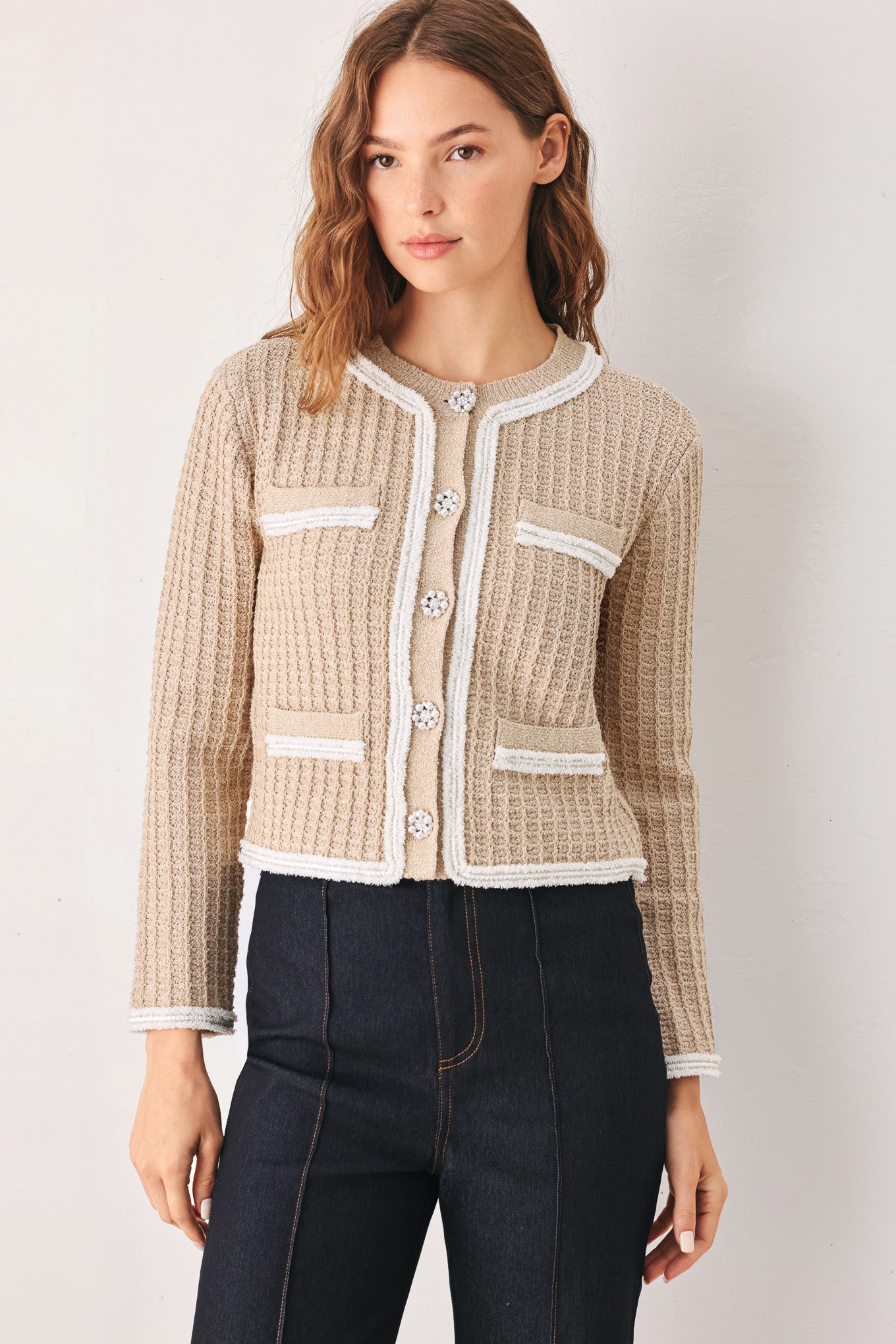A woman wearing a beige textured knit cardigan with white trim and decorative buttons | FREEMARKET