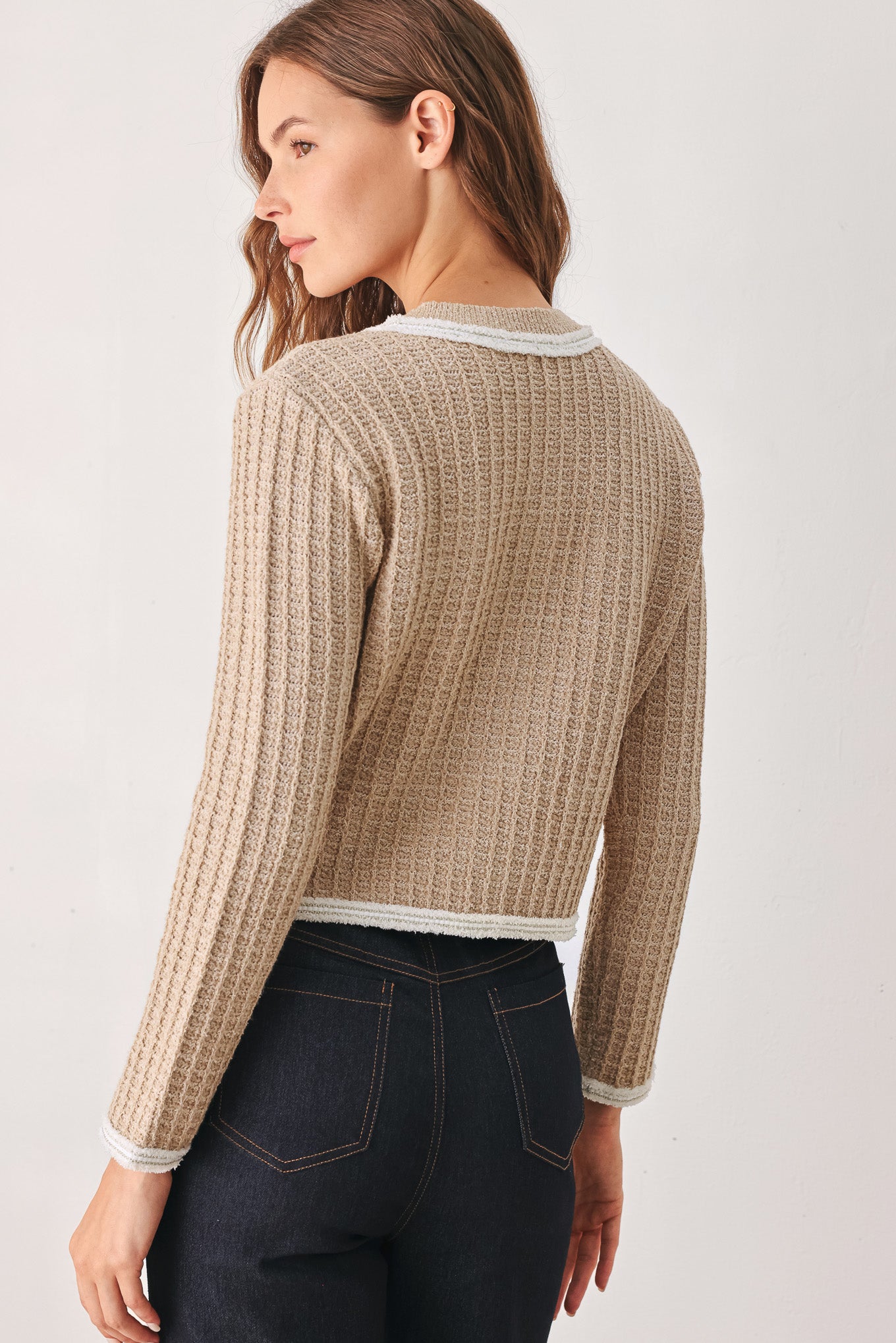 A woman wearing a beige textured knit cardigan with white trim and decorative buttons | FREEMARKET