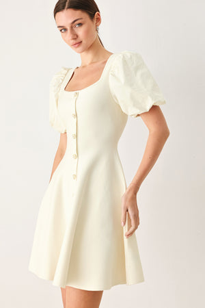 Woman wearing a light ivory sweater knit mini dress with puff sleeves featuring U neckline and front button down | FREEMARKET