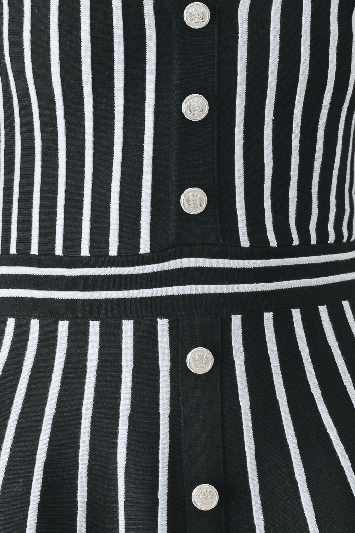 A woman modeling a short-sleeve V-neck dress with vertical black and silver stripes, a buttoned front, and a flared skirt | FREEMARKET