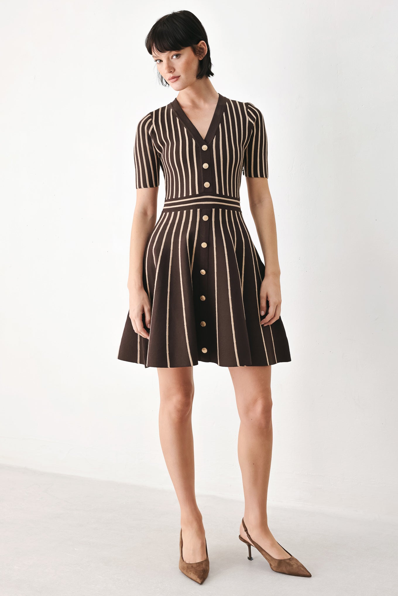 A woman modeling a short-sleeve V-neck dress with vertical brown and beige stripes, a buttoned front, and a flared skirt | FREEMARKET
