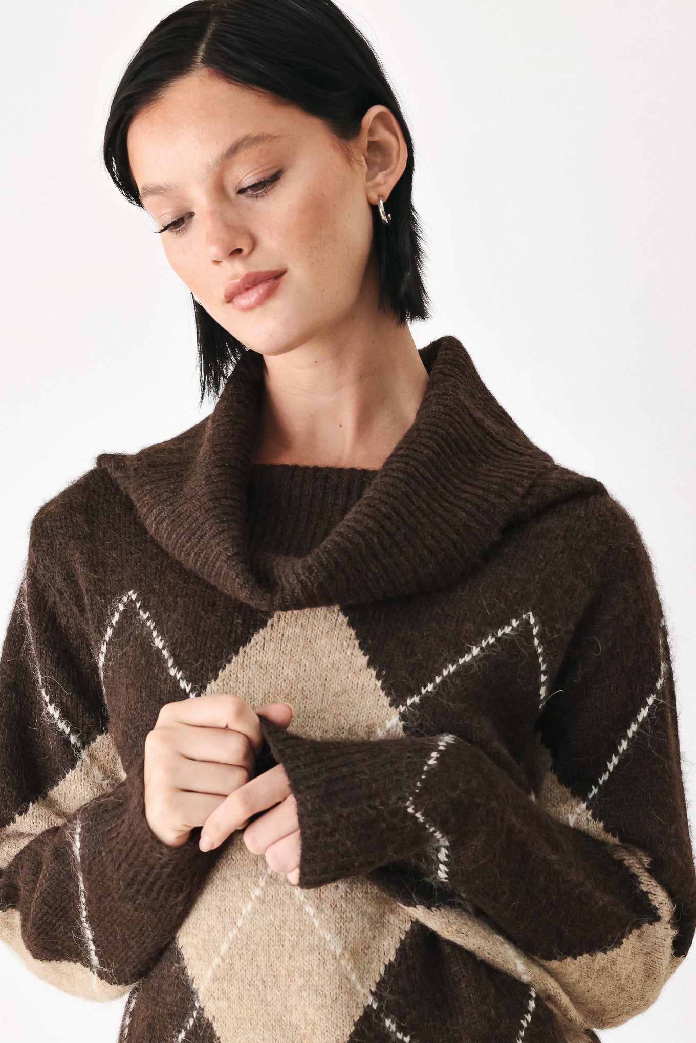 A woman wearing a brown and beige argyle knit sweater with a high folded collar | FREEMARKET