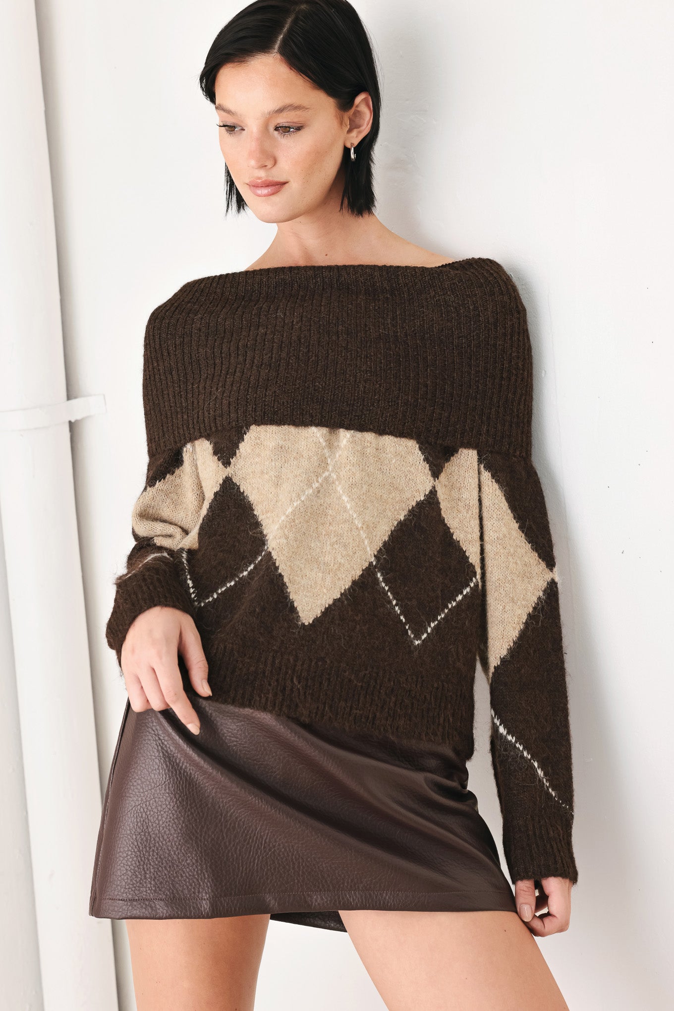 A woman wearing a brown and beige argyle knit sweater with a high folded collar | FREEMARKET