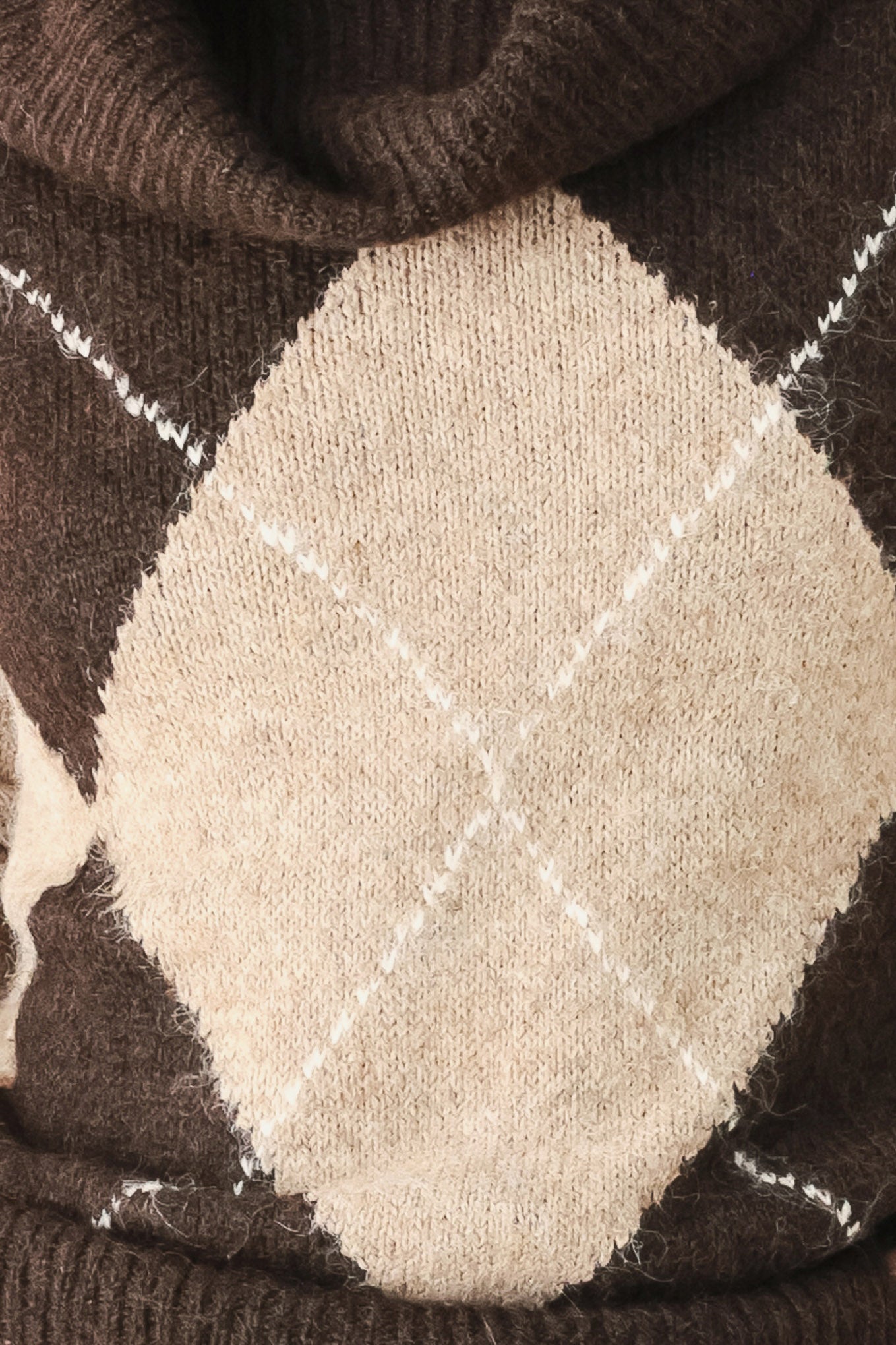 A woman wearing a brown and beige argyle knit sweater with a high folded collar | FREEMARKET
