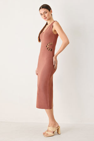 Woman wearing a clay colored sweater knit midi dress featuring V neckline and side cut out in a flower shape | FREEMARKET