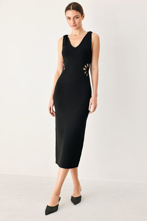 Woman wearing a black sweater knit midi dress featuring V neckline and side cut out in a flower shape | FREEMARKET
