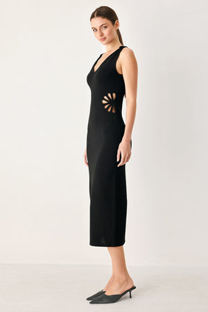 Woman wearing a black sweater knit midi dress featuring V neckline and side cut out in a flower shape | FREEMARKET