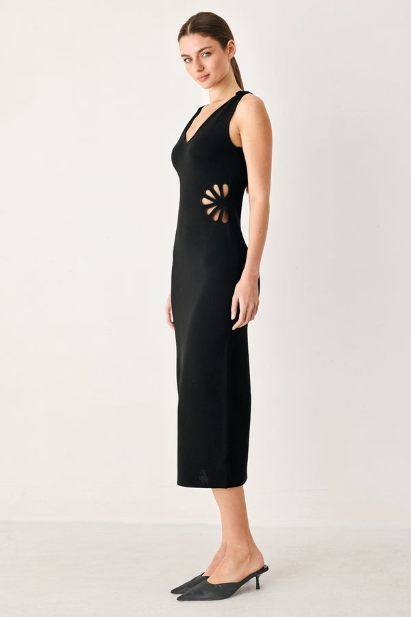 Woman wearing a black sweater knit midi dress featuring V neckline and side cut out in a flower shape | FREEMARKET