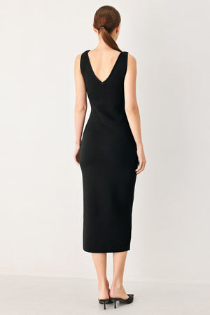 Woman wearing a black sweater knit midi dress featuring V neckline and side cut out in a flower shape | FREEMARKET