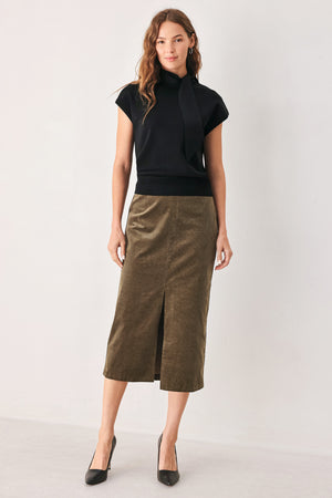 A woman wearing a black short-sleeve knit top with a high mock neck and a large draped tie detail at the front | FREEMARKET