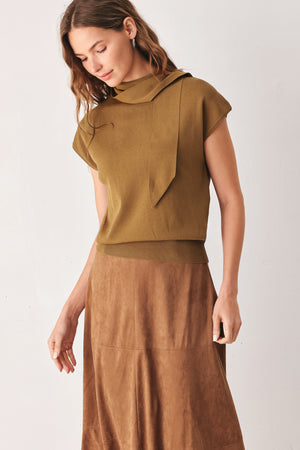 A woman wearing a camel short-sleeve knit top with a high mock neck and a large draped tie detail at the front | FREEMARKET