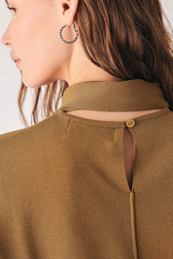 A woman wearing a camel short-sleeve knit top with a high mock neck and a large draped tie detail at the front | FREEMARKET