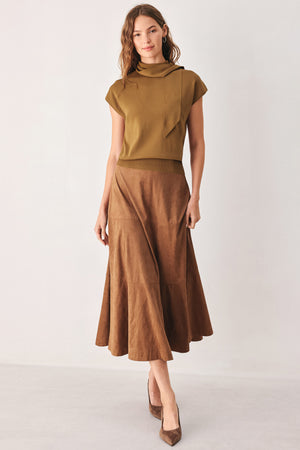 A woman wearing a camel short-sleeve knit top with a high mock neck and a large draped tie detail at the front | FREEMARKET