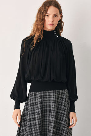 A woman wearing a black long-sleeve blouse with a high gathered neckline and pearl-like embellishments | FREEMARKET