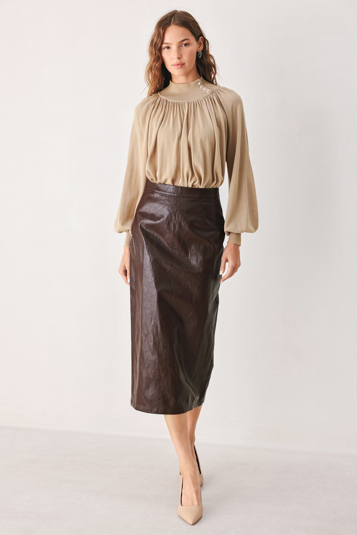 A woman wearing a taupe long-sleeve blouse with a high gathered neckline and pearl-like embellishments | FREEMARKET