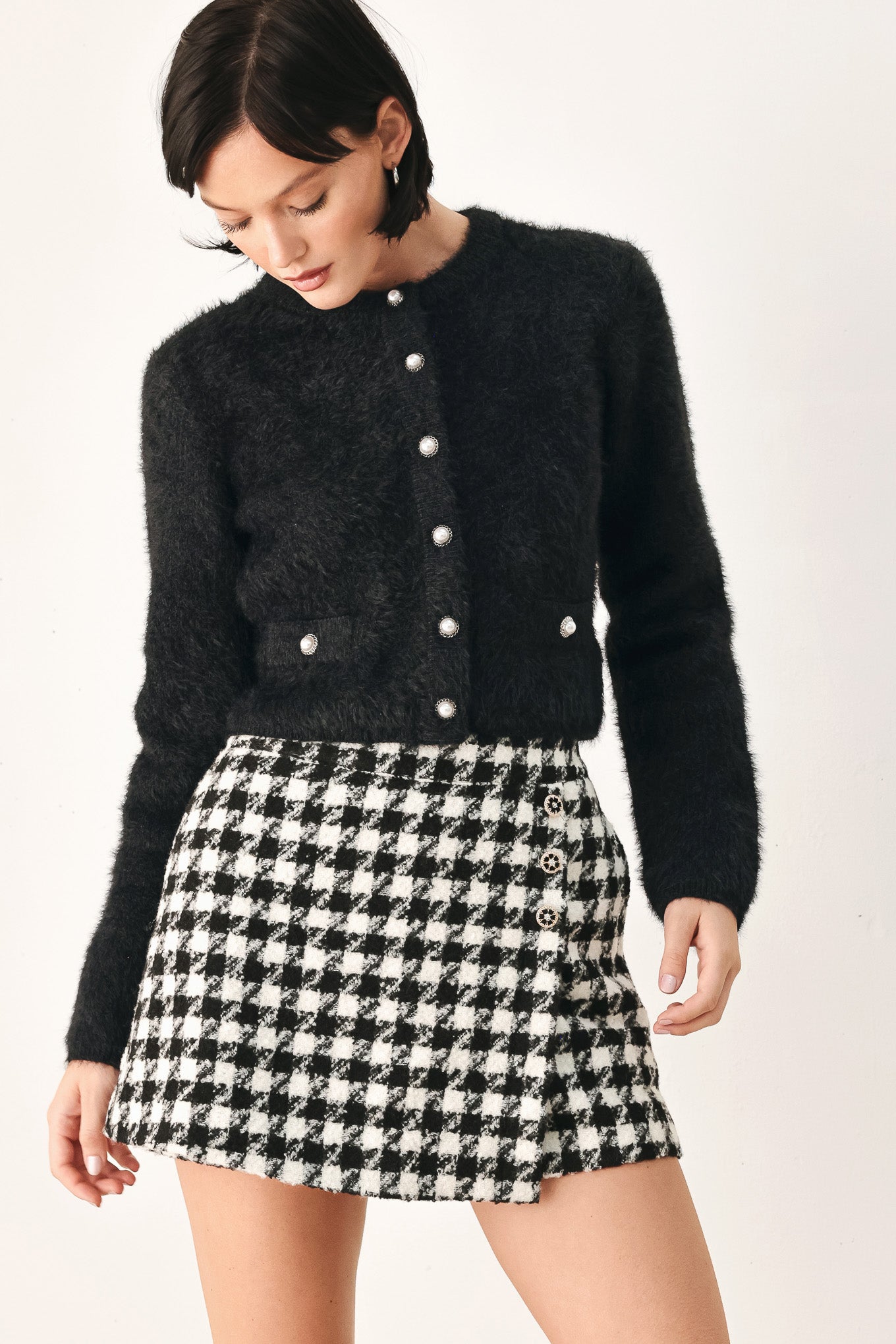 A model wearing a black fuzzy cropped cardigan with buttons | FREEMARKET
