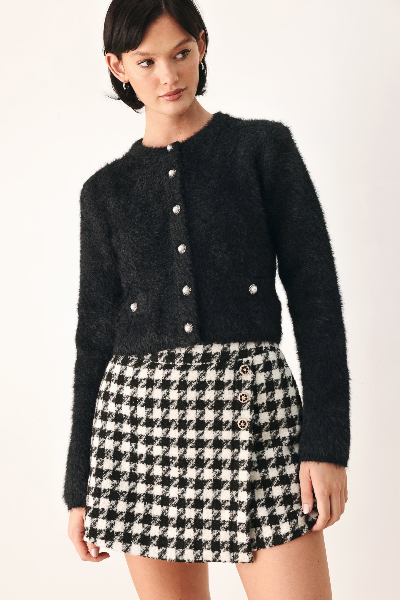 A model wearing a black furry textured cropped cardigan with buttons | FREEMARKET