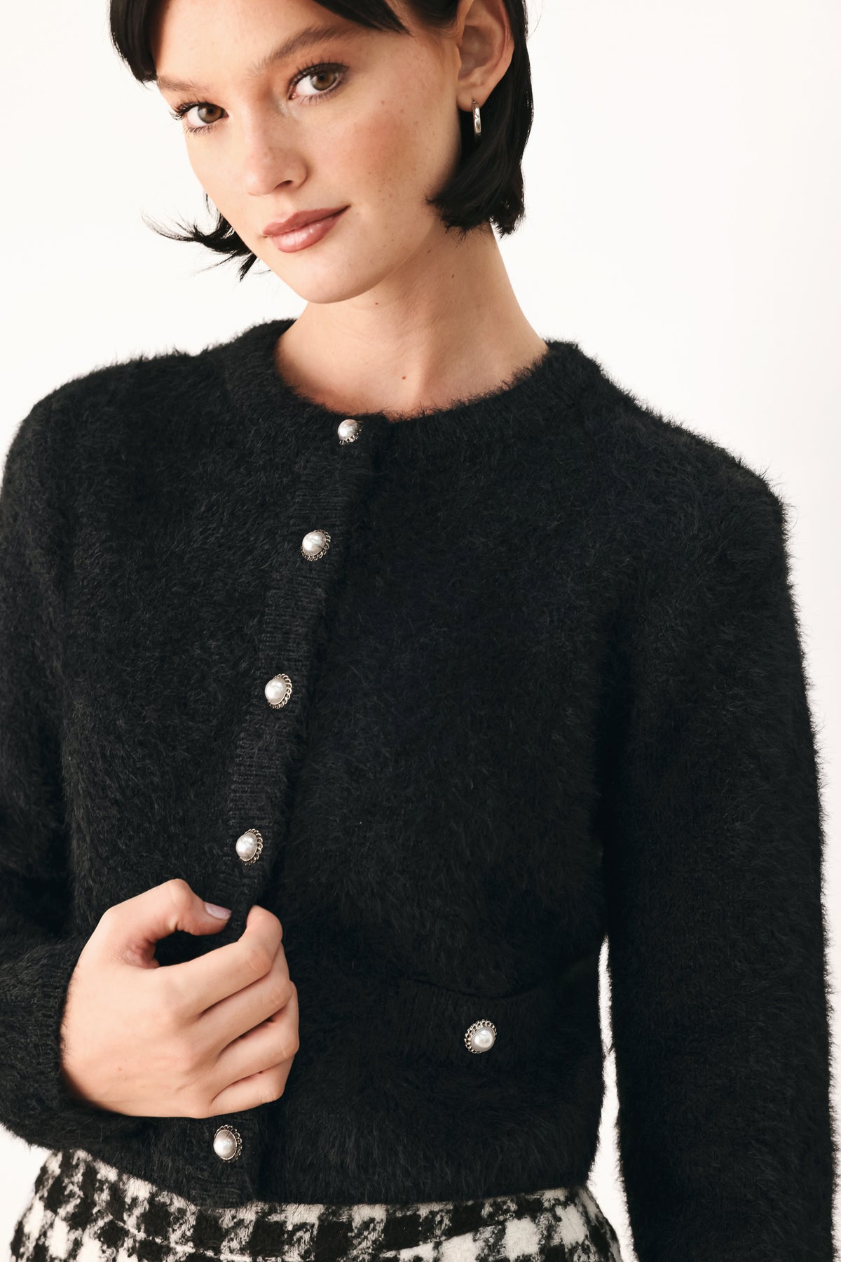 A model wearing a black fuzzy cropped cardigan with buttons | FREEMARKET