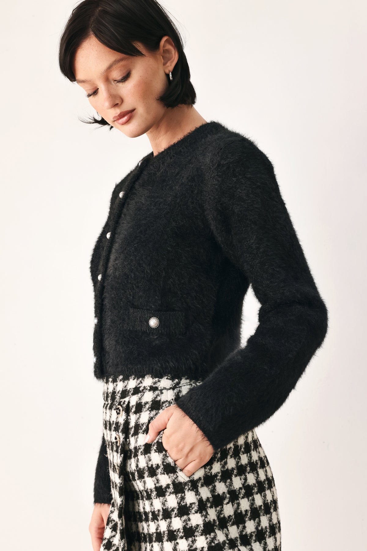 A model wearing a black fuzzy cropped cardigan with buttons | FREEMARKET