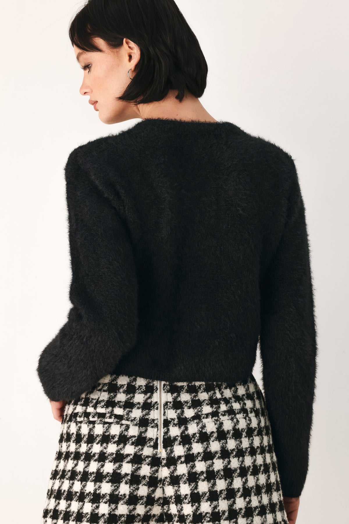 A model wearing a black fuzzy cropped cardigan with buttons | FREEMARKET