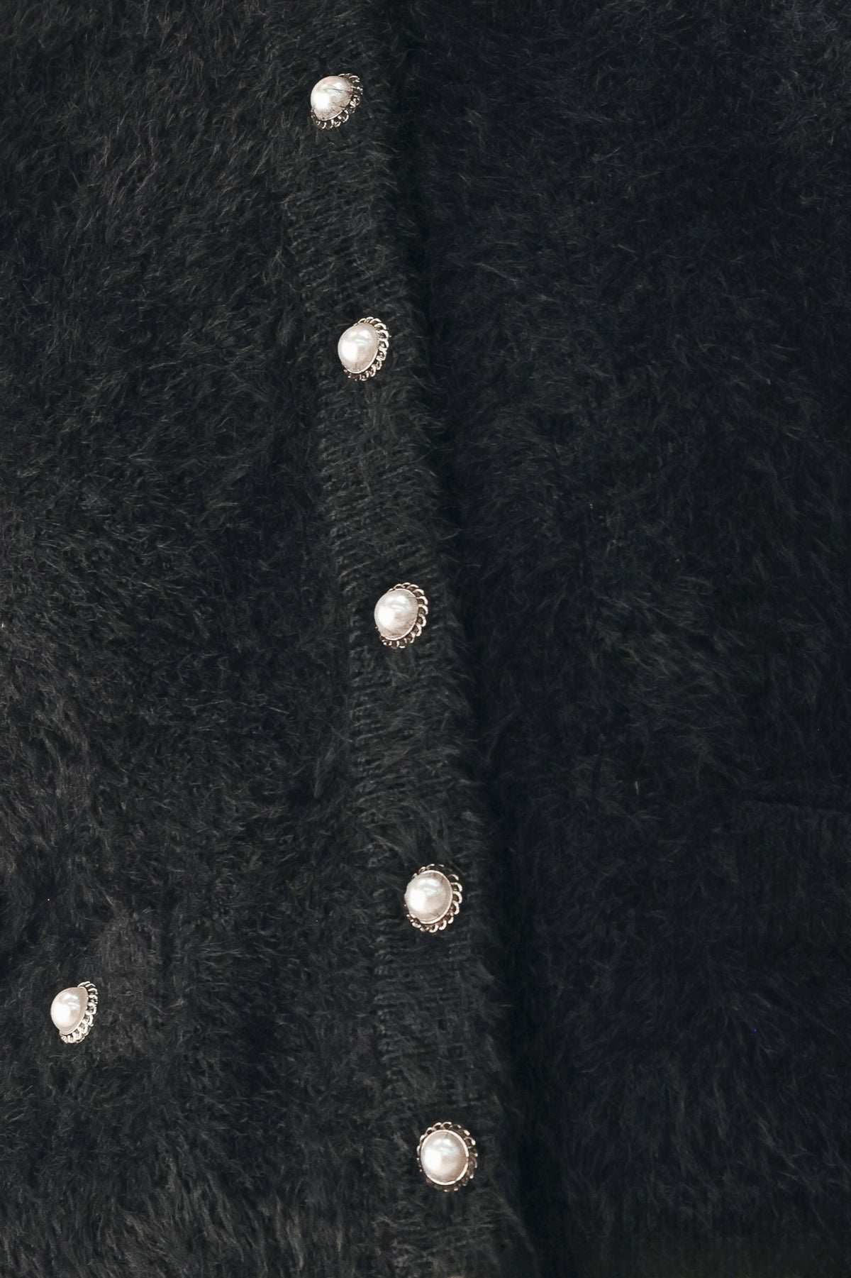 A model wearing a black fuzzy cropped cardigan with buttons | FREEMARKET
