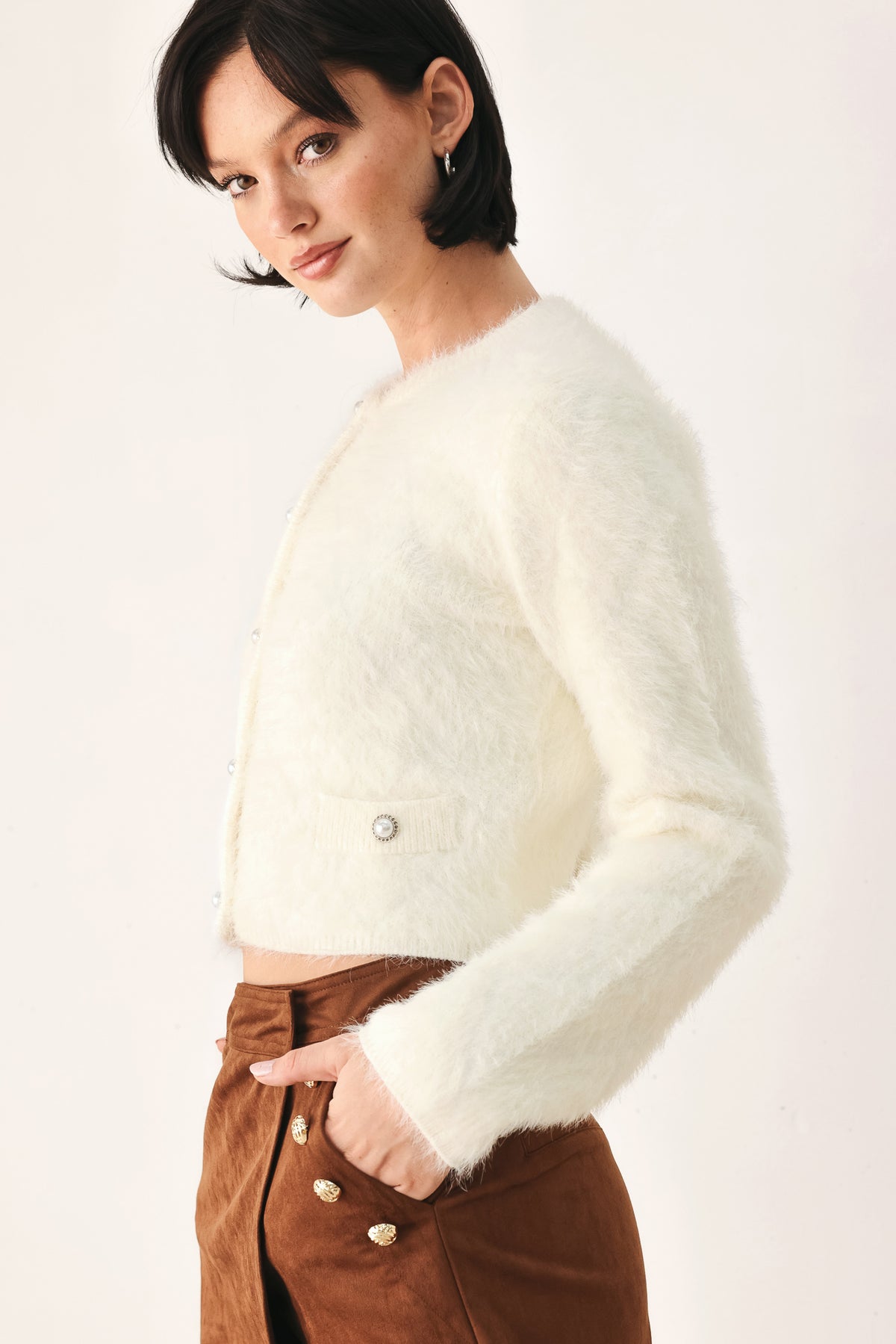 A model wearing an ivory fuzzy cropped cardigan with buttons | FREEMARKET