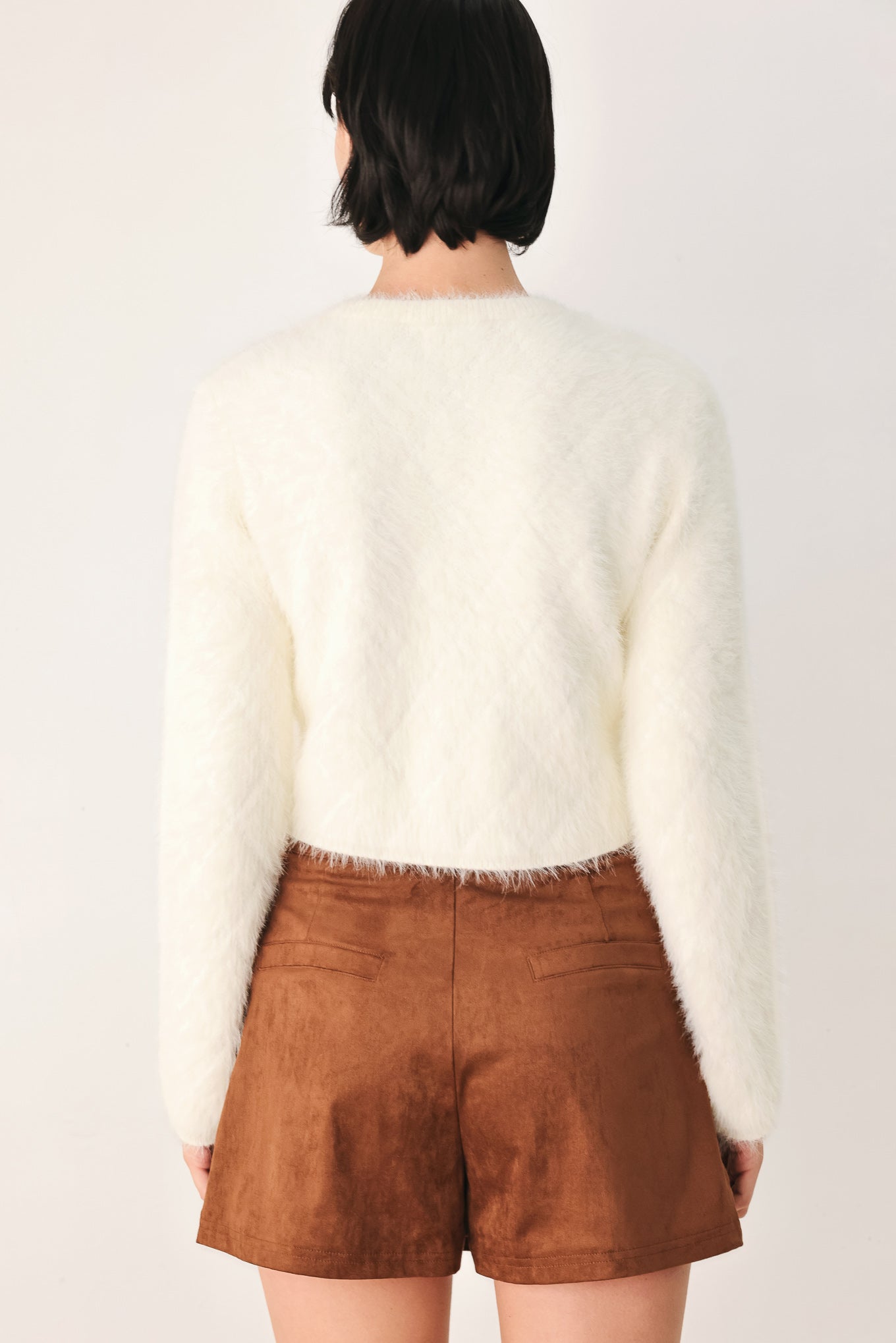 A model wearing an ivory fuzzy cropped cardigan with buttons | FREEMARKET
