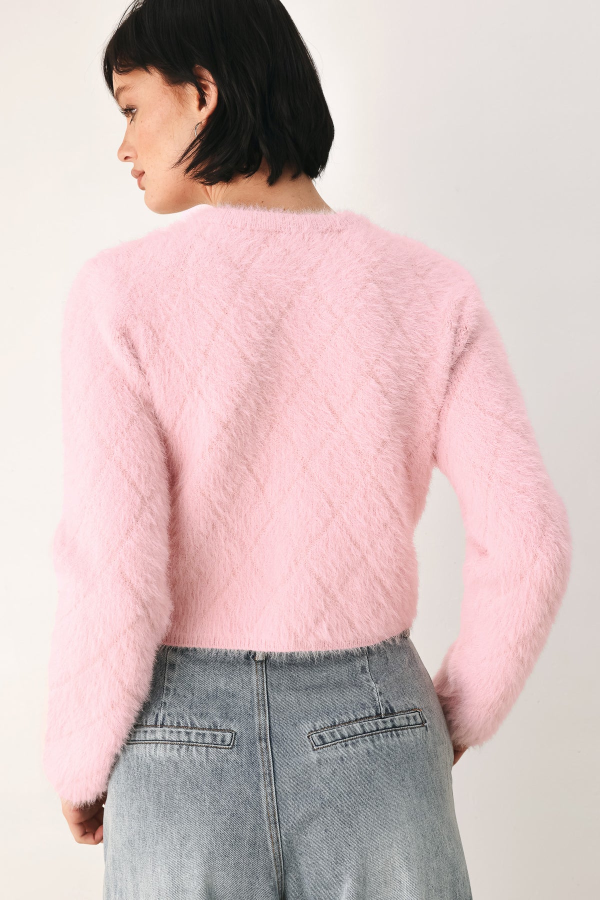 A model wearing a pink fuzzy cropped cardigan with buttons | FREEMARKET