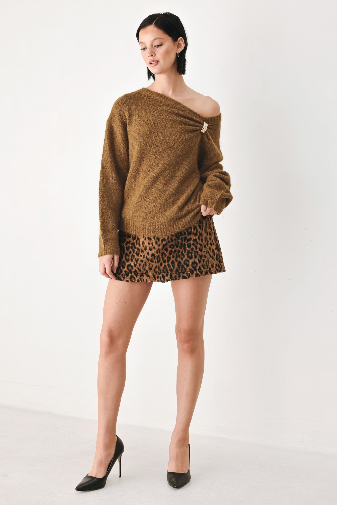 A woman modeling a camel knit sweater with a unique draped neckline and a small gold button accent | FREEMARKET