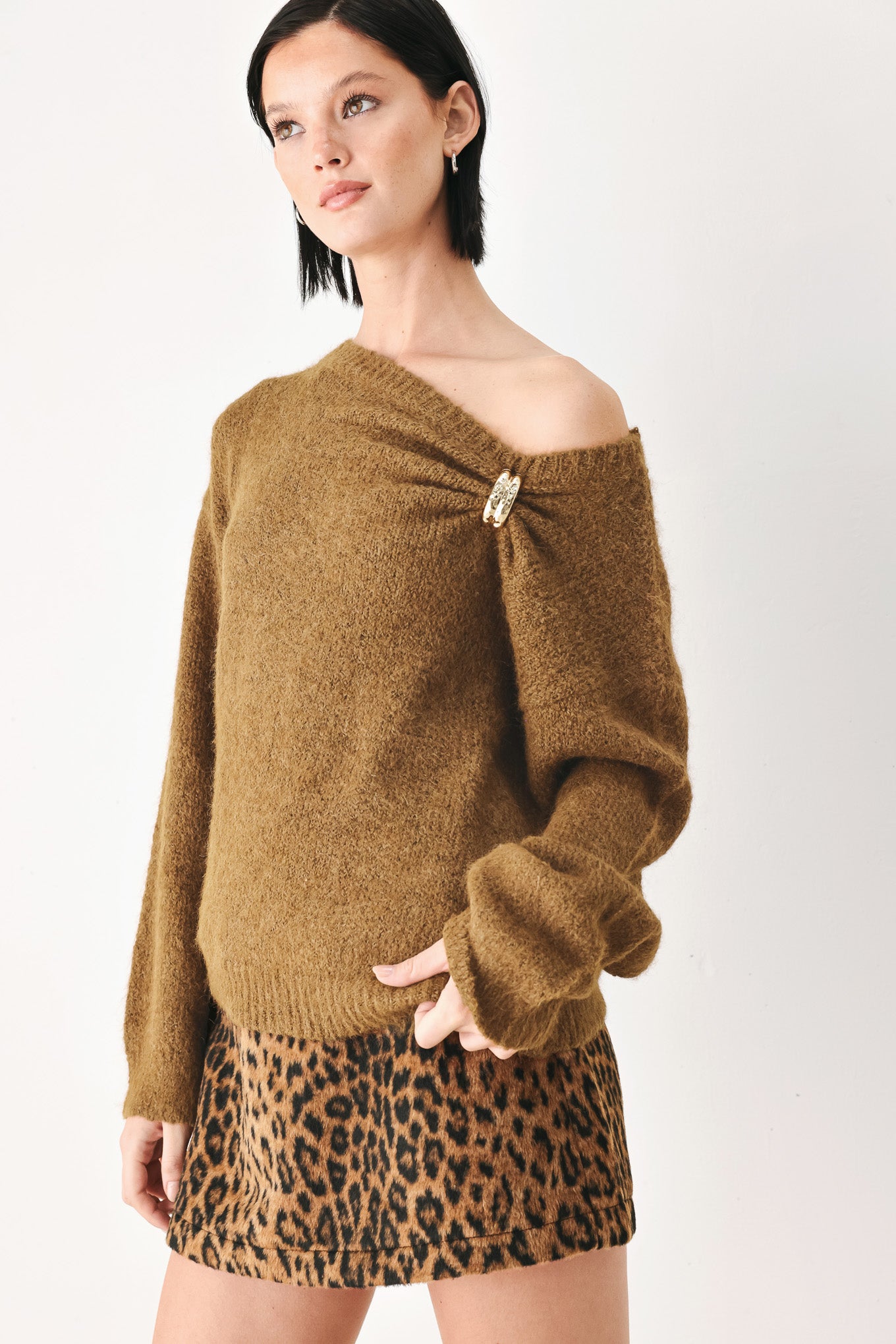 A woman modeling a camel knit sweater with a unique draped neckline and a small gold button accent | FREEMARKET