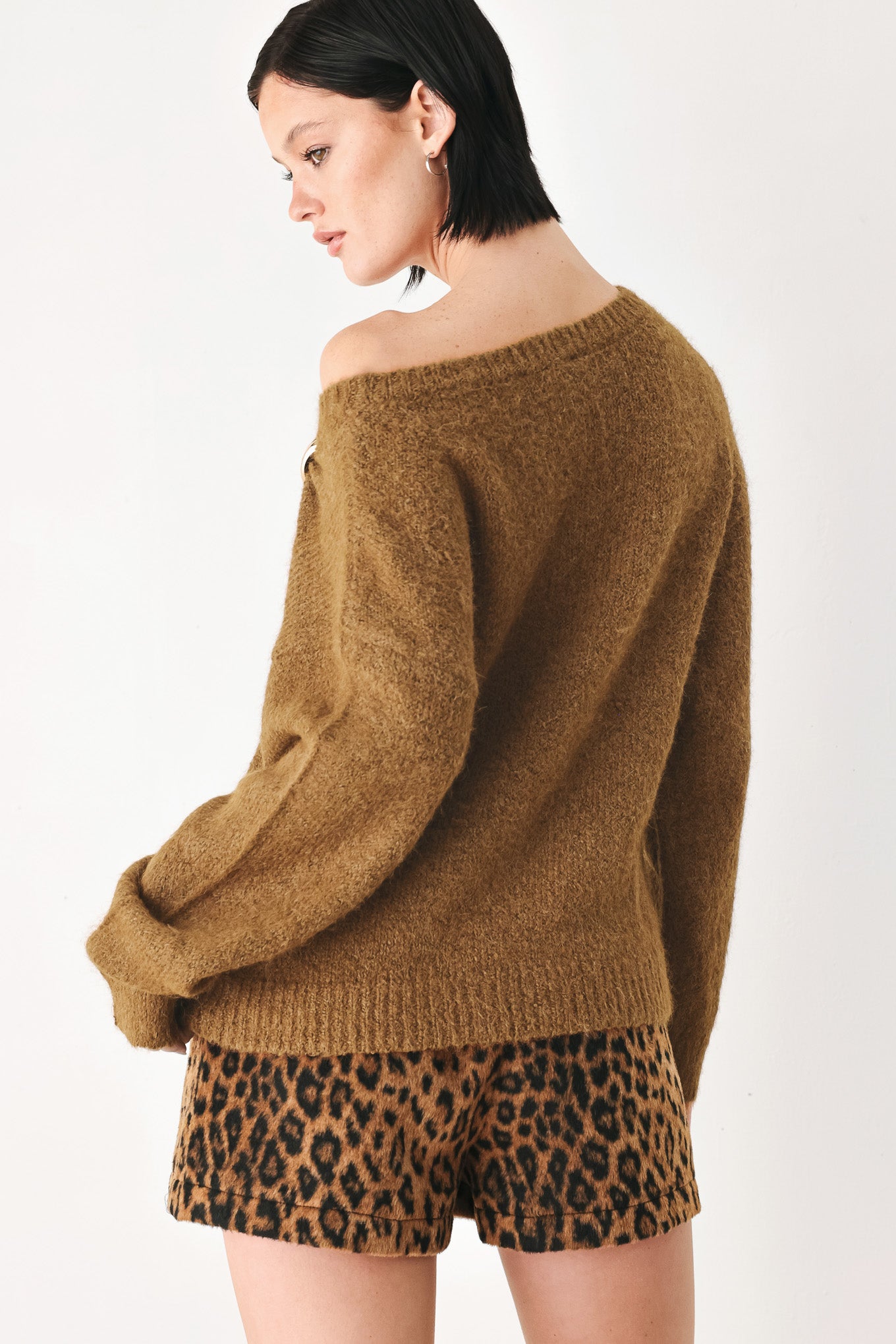 A woman modeling a camel knit sweater with a unique draped neckline and a small gold button accent | FREEMARKET