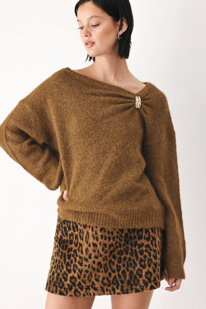 A woman modeling a camel knit sweater with a unique draped neckline and a small gold button accent | FREEMARKET