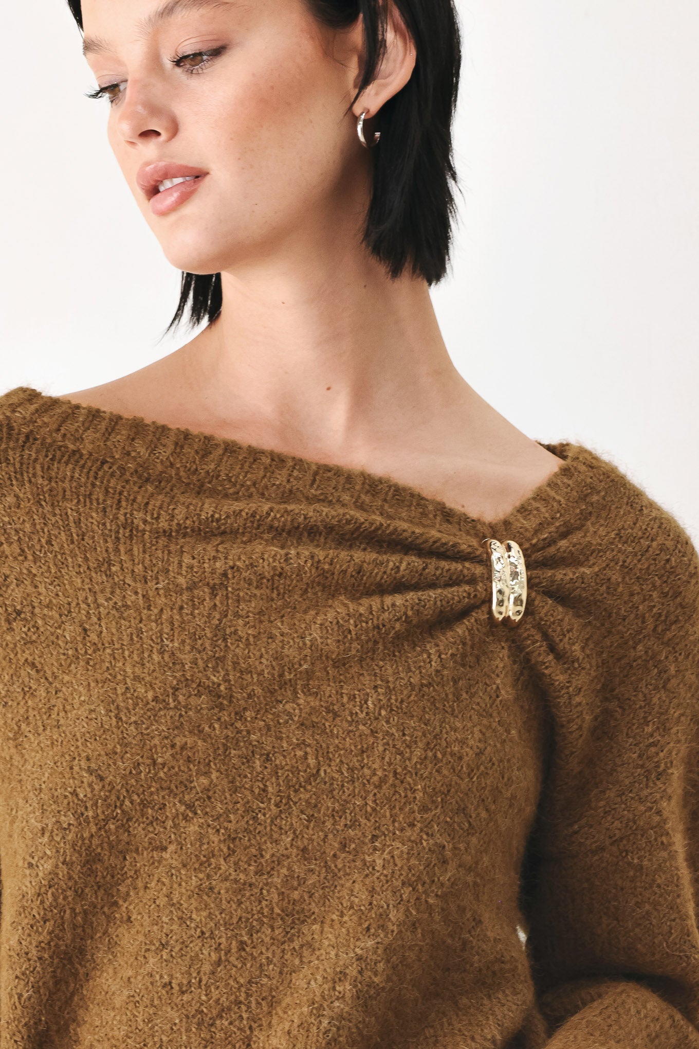 A woman modeling a camel knit sweater with a unique draped neckline and a small gold button accent | FREEMARKET