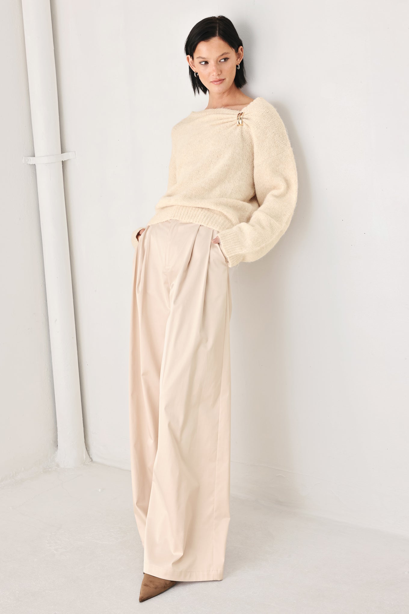 A woman modeling a ivory knit sweater with a unique draped neckline and a small gold button accent | FREEMARKET