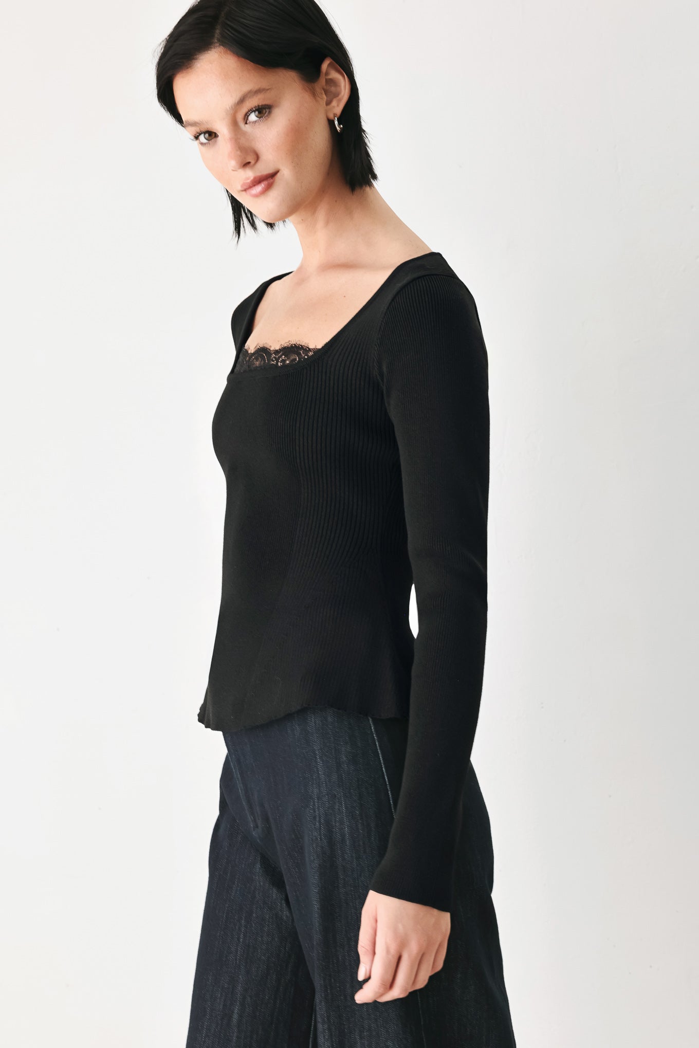 A model wearing a black long-sleeve top with a square neckline and delicate lace trim | FREEMARKET