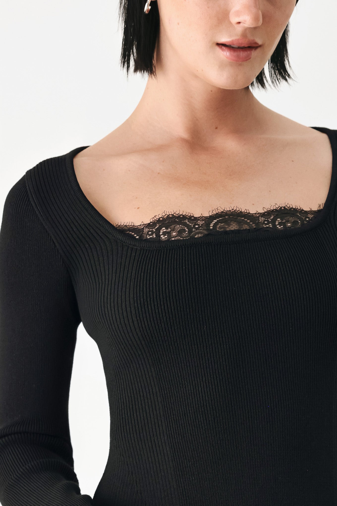 A model wearing a black long-sleeve top with a square neckline and delicate lace trim | FREEMARKET