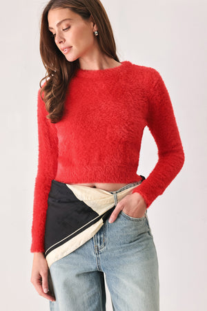 A woman wearing a bright red fuzzy long-sleeve crop top | FREEMARKET