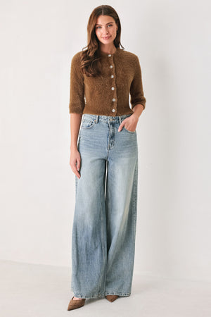 A woman wearing a brown fuzzy cropped cardigan with decorative silver buttons down the front | FREEMARKET