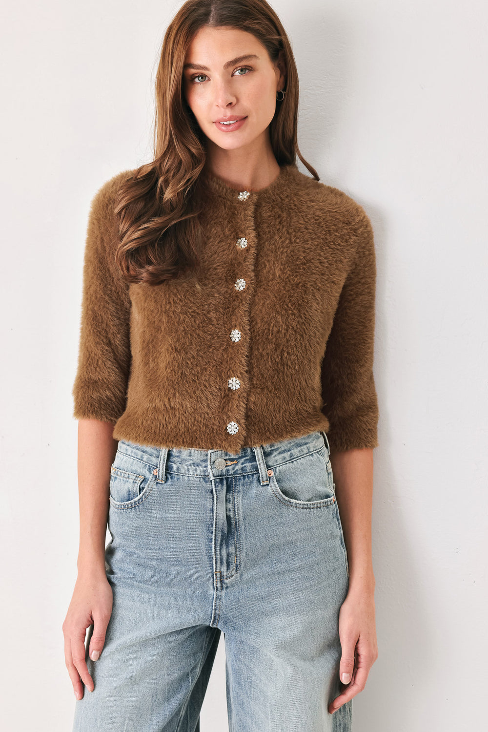 A woman wearing a brown fuzzy cropped cardigan with decorative silver buttons down the front | FREEMARKET