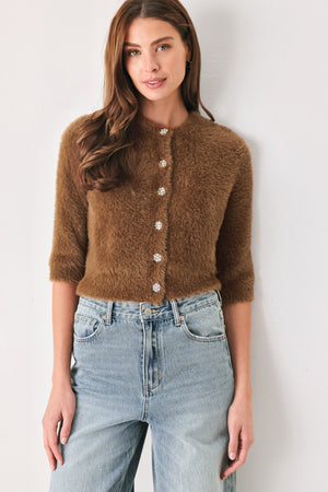 A woman wearing a brown fuzzy cropped cardigan with decorative silver buttons down the front | FREEMARKET