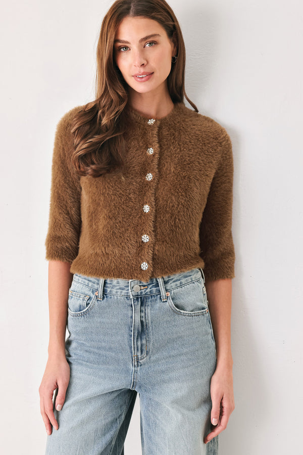 A woman wearing a brown fuzzy cropped cardigan with decorative silver buttons down the front | FREEMARKET