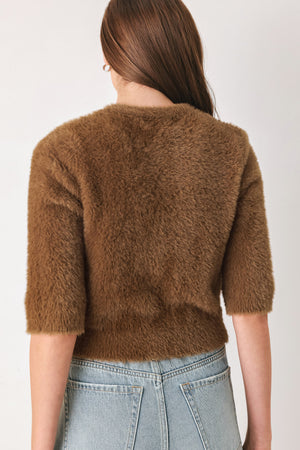 A woman wearing a brown fuzzy cropped cardigan with decorative silver buttons down the front | FREEMARKET