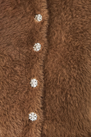 A woman wearing a brown fuzzy cropped cardigan with decorative silver buttons down the front | FREEMARKET
