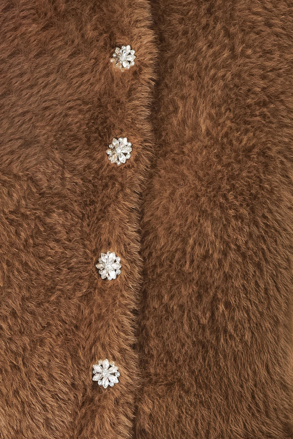 A woman wearing a brown fuzzy cropped cardigan with decorative silver buttons down the front | FREEMARKET