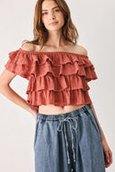 A woman wearing a terracotta-colored off-the-shoulder ruffled crop top | FREEMARKET