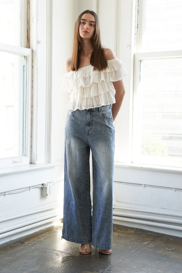 A woman wearing a white-colored off-the-shoulder ruffled crop top | FREEMARKET